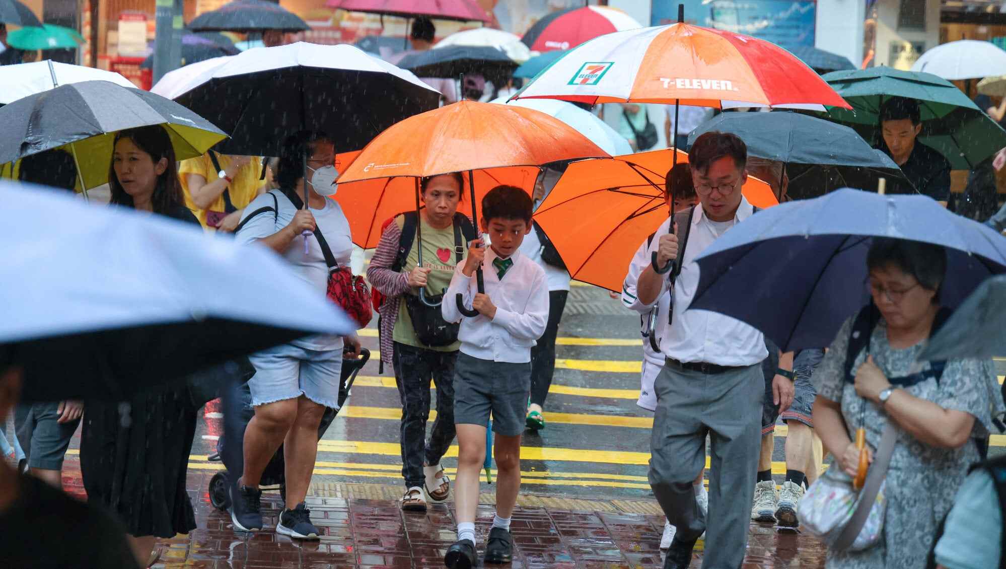 Students brave heavy rain in Wan Chai. Pack an umbrella to stay dry on your big day. Photo: Nora Tam