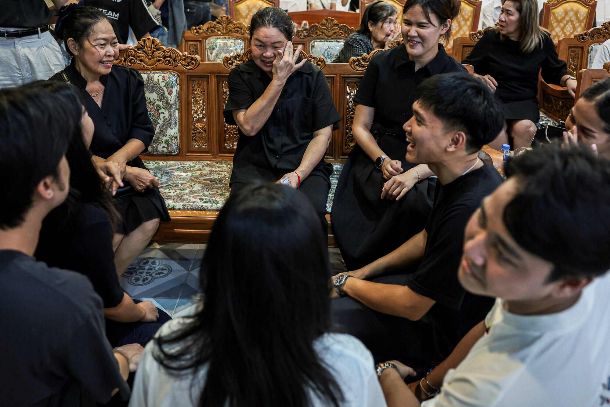 Natnichakarn Nakplung, 64, the mother of Nanchanatporn Nakplung, 31, one of the teachers killed in the shooting at Debsirin Nonthaburi School, sits with Nanchanatporn’s friends during the funeral at a temple in Nonthaburi province, on the outskirts of Bangkok. Photo: Reuters