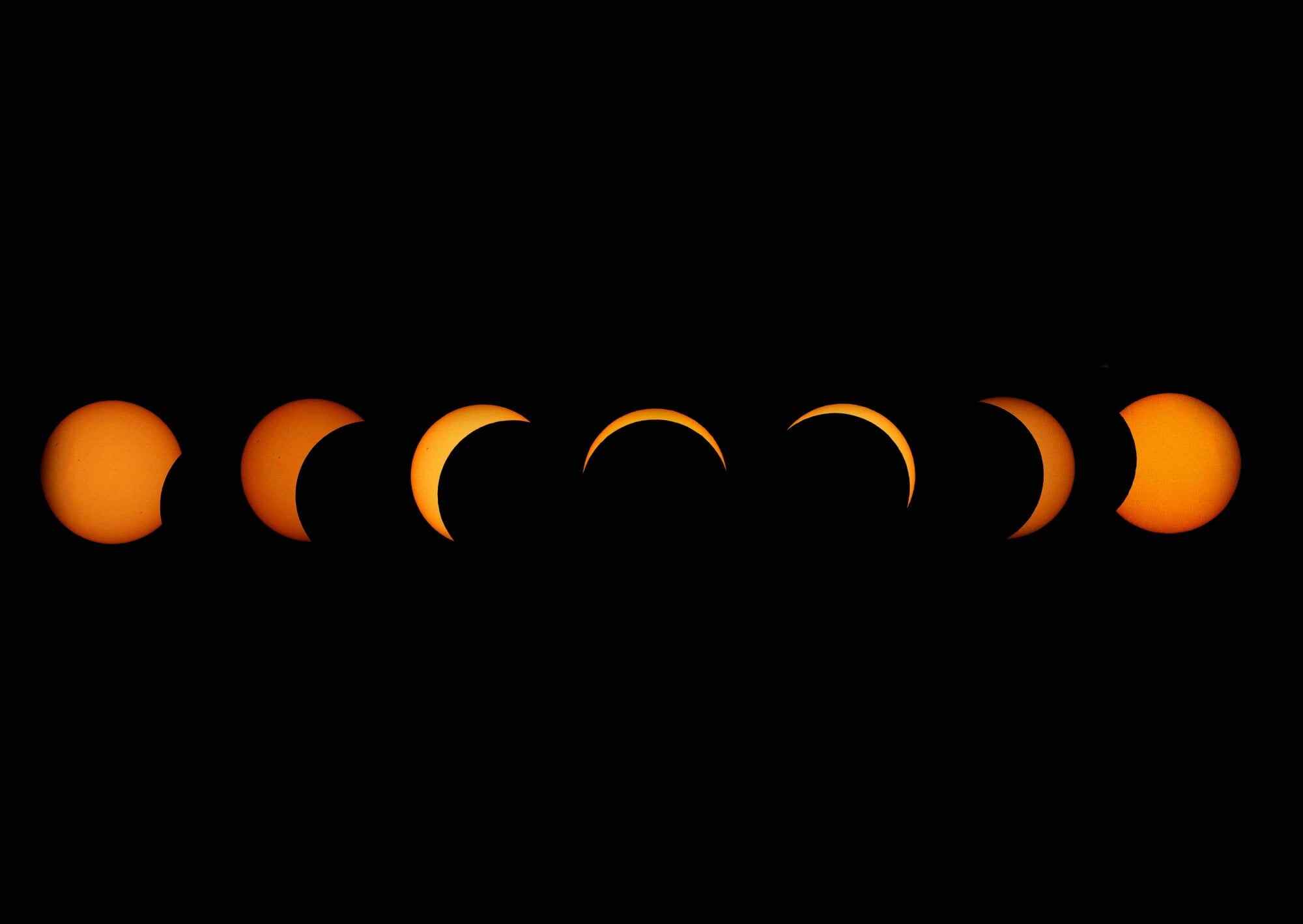This composite image shows a sequence of the moon passing in front of the sun as seen from Greenwich Park in London, Britain, on August 12. Photo: EPA