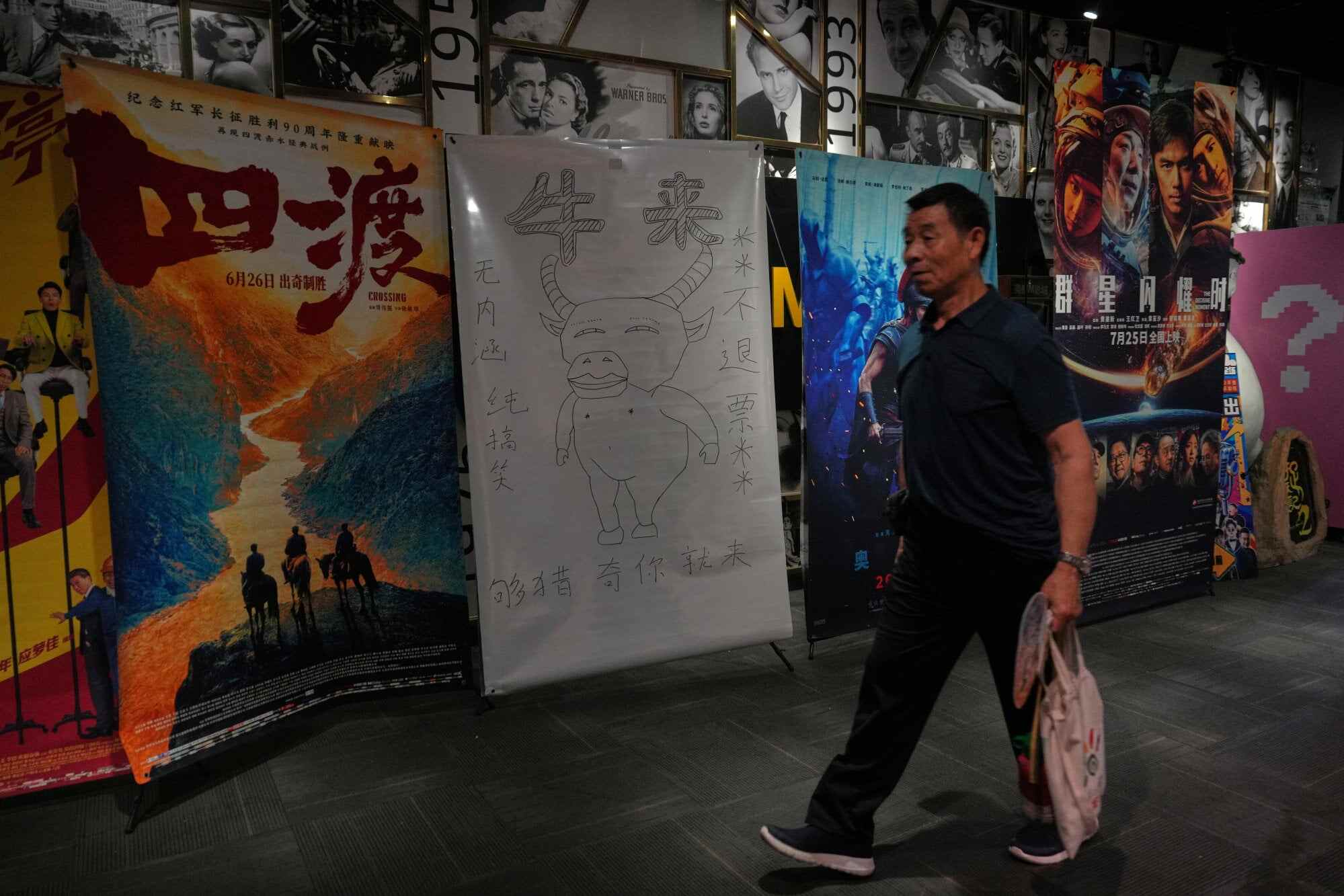 A man walks by a hand-drawn poster promoting the Chinese animated film “Niu Lai” at a cinema in Beijing. The film traces Niu Lai’s relationship with his mother. Photo: AP