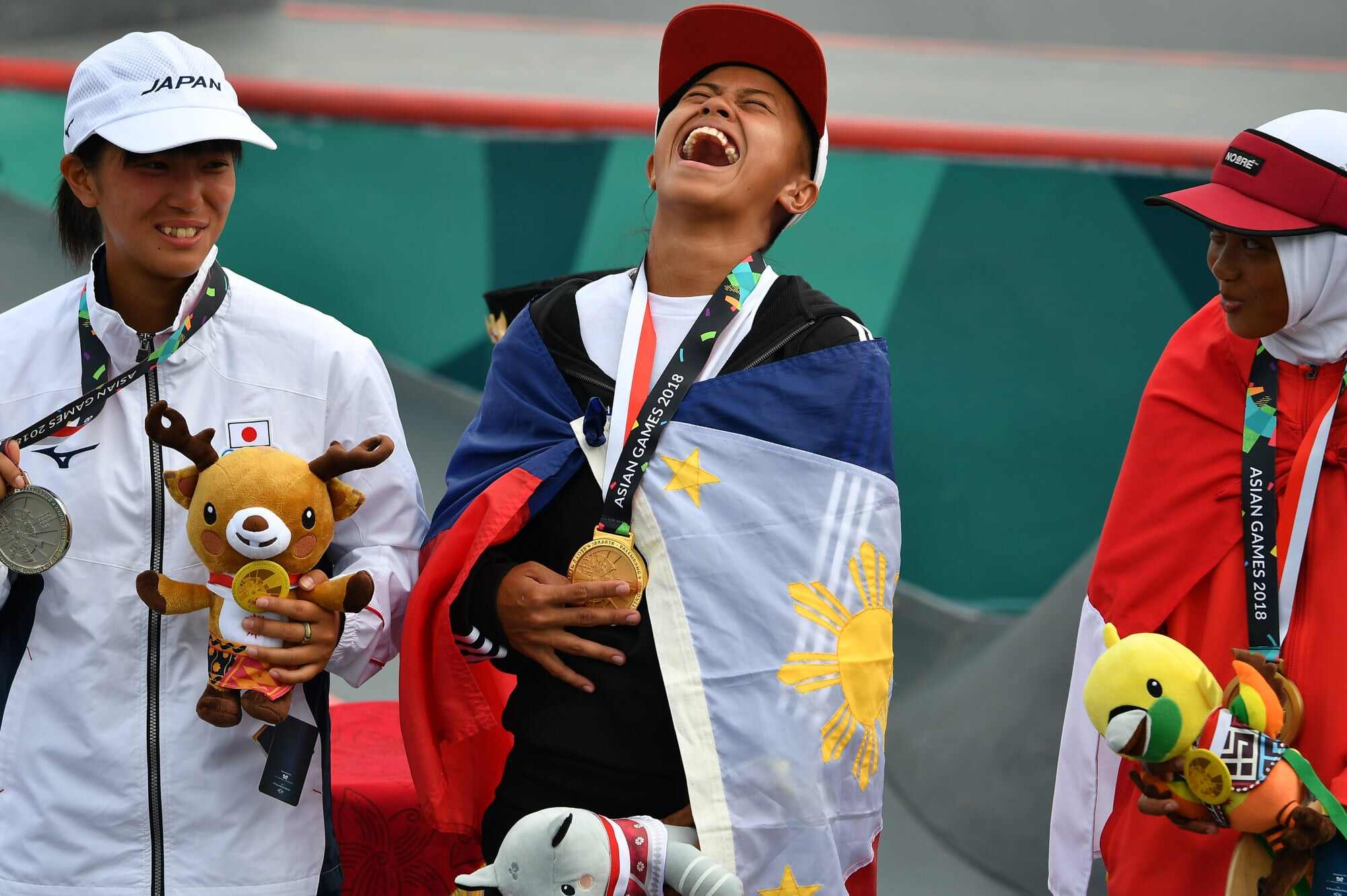 Bronze medallist Indonesia’s Bunga Nyimas (right) looks on during the awards ceremony for the women’s skateboard street event during the 2018 Asian Games in Palembang, Indonesia. Photo: AFP