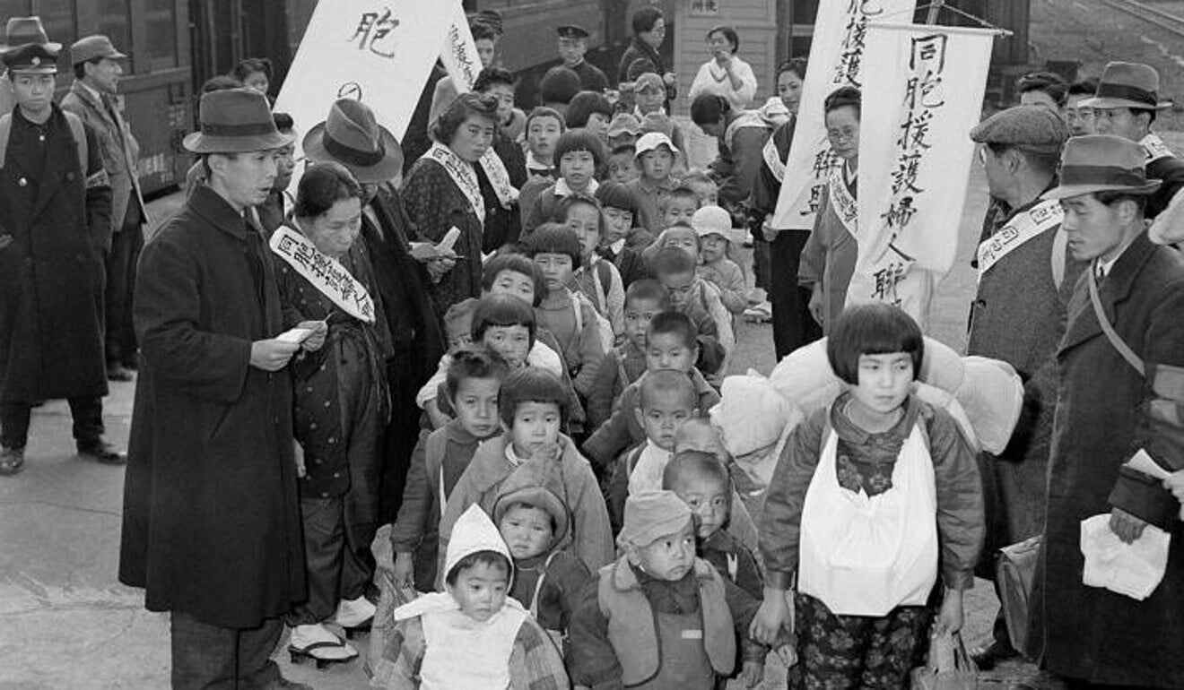 Sober-faced young Japanese war orphans from Manchuria arrive in Tokyo, Japan, and walk double-file across a railroad station platform. A 10-year-old girl, Ishiko Hosoda, (right foreground) carries the ashes of her brother and mother, all of whom died in Manchuria. Her father is a prisoner of war of the Red Army in Siberia.