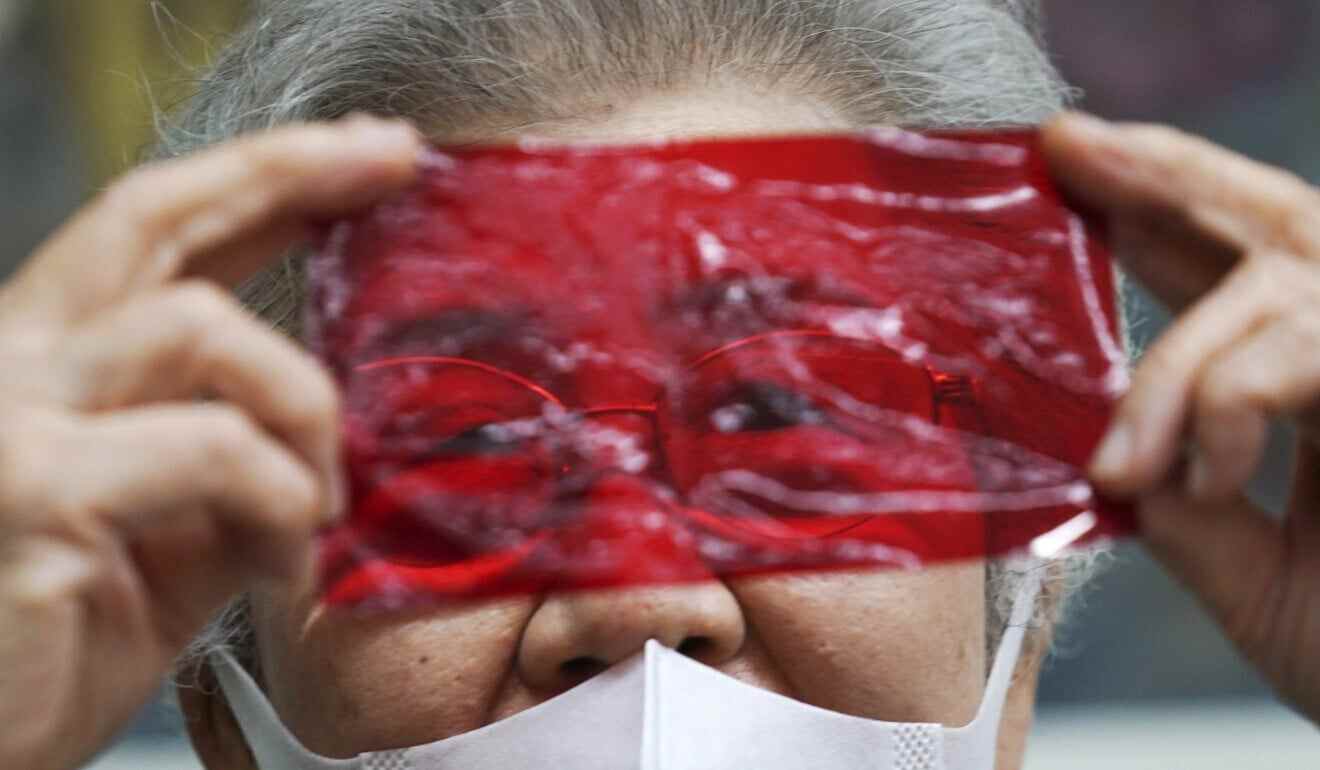 Kisako Motoki, 86, speaks, looking though a red cellophane depicting what she saw the atmosphere of the night of the Great Tokyo Air Raid on March 10, 1945. Photo:AP
