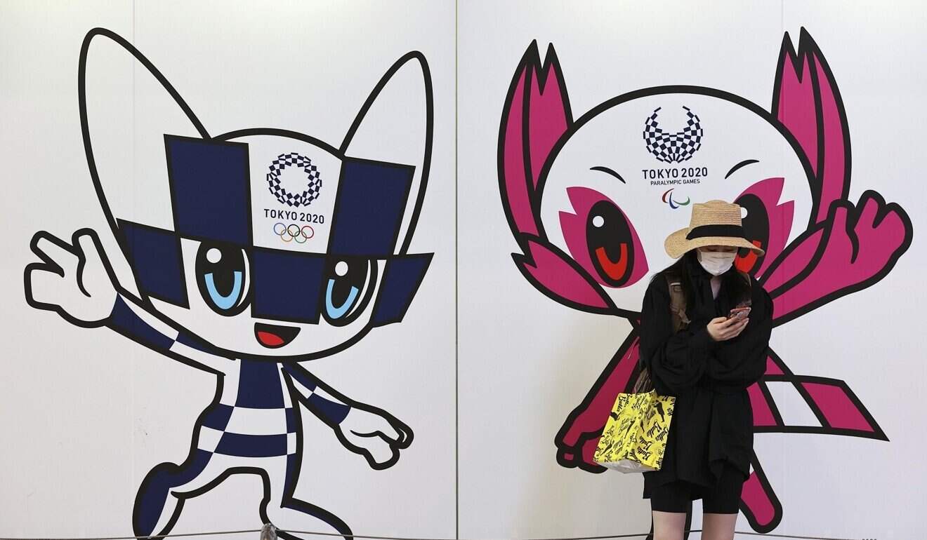 A woman stands in front of illustrations showing Miraitowa (L) and Someity (R), official mascots of the Tokyo Olympics and Paralympics, in Kobe, Japan. Photo: Kyodo